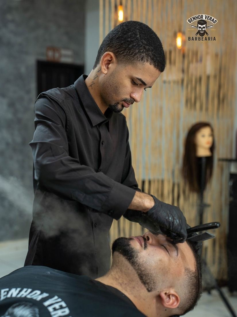 Barbeiro preparando a barba do cliente com vapor