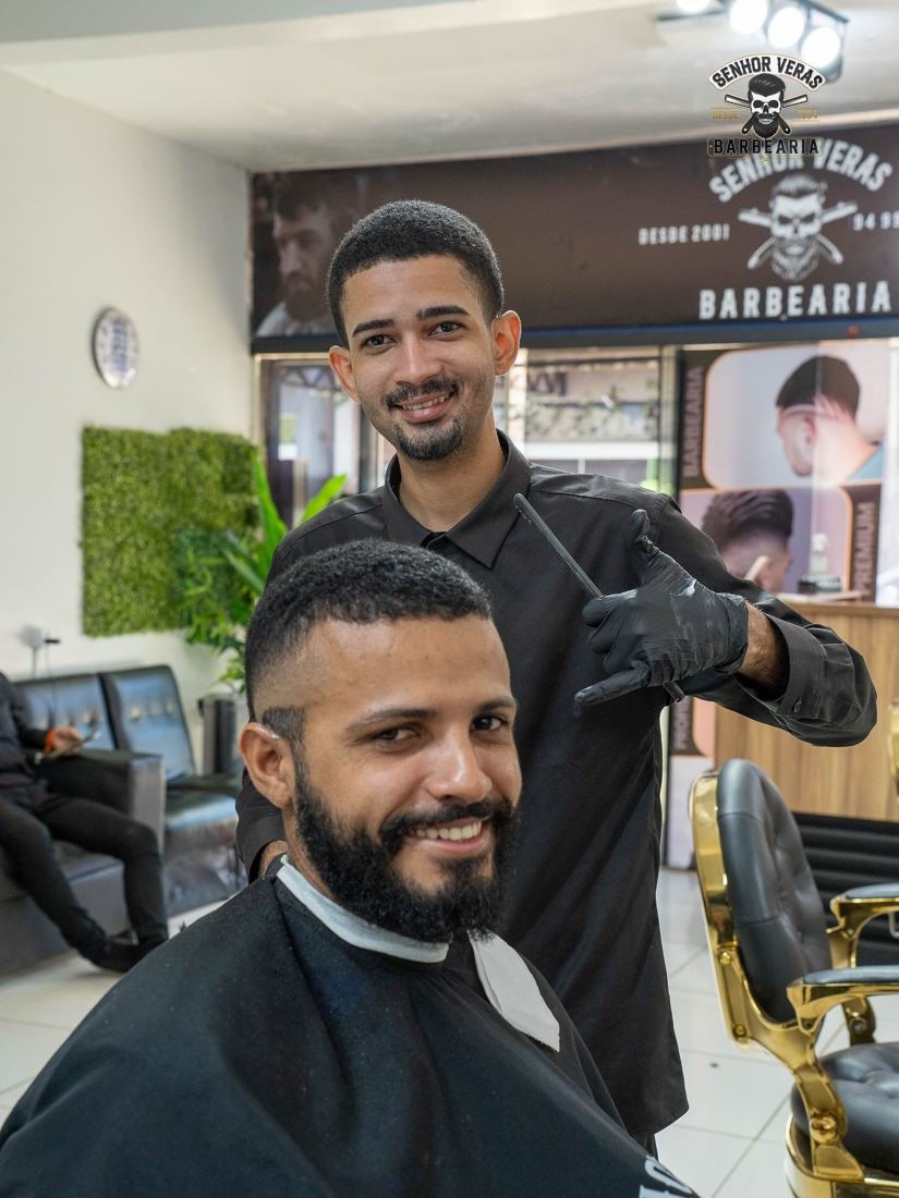Barbeiro e cliente sorrindo após o corte